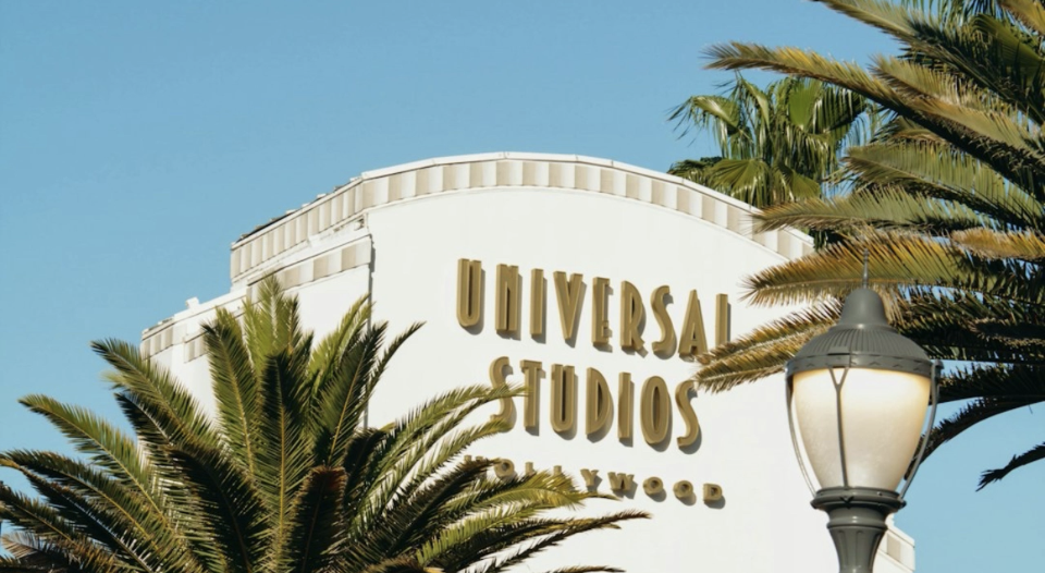 Universal Studios Hollywood entrance arch framed by palm trees