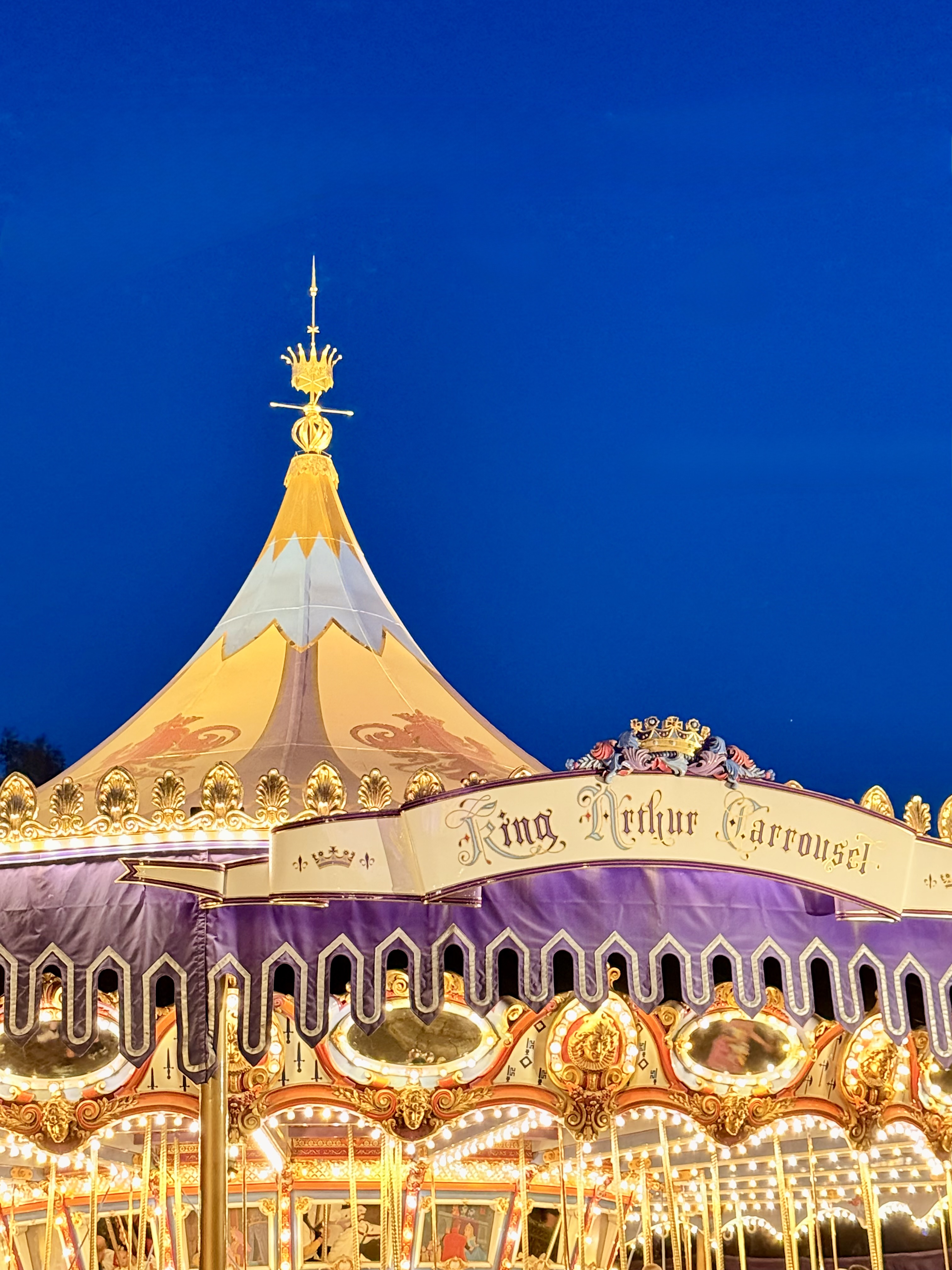 King Arthur Carrousel canopy against a deep blue sky