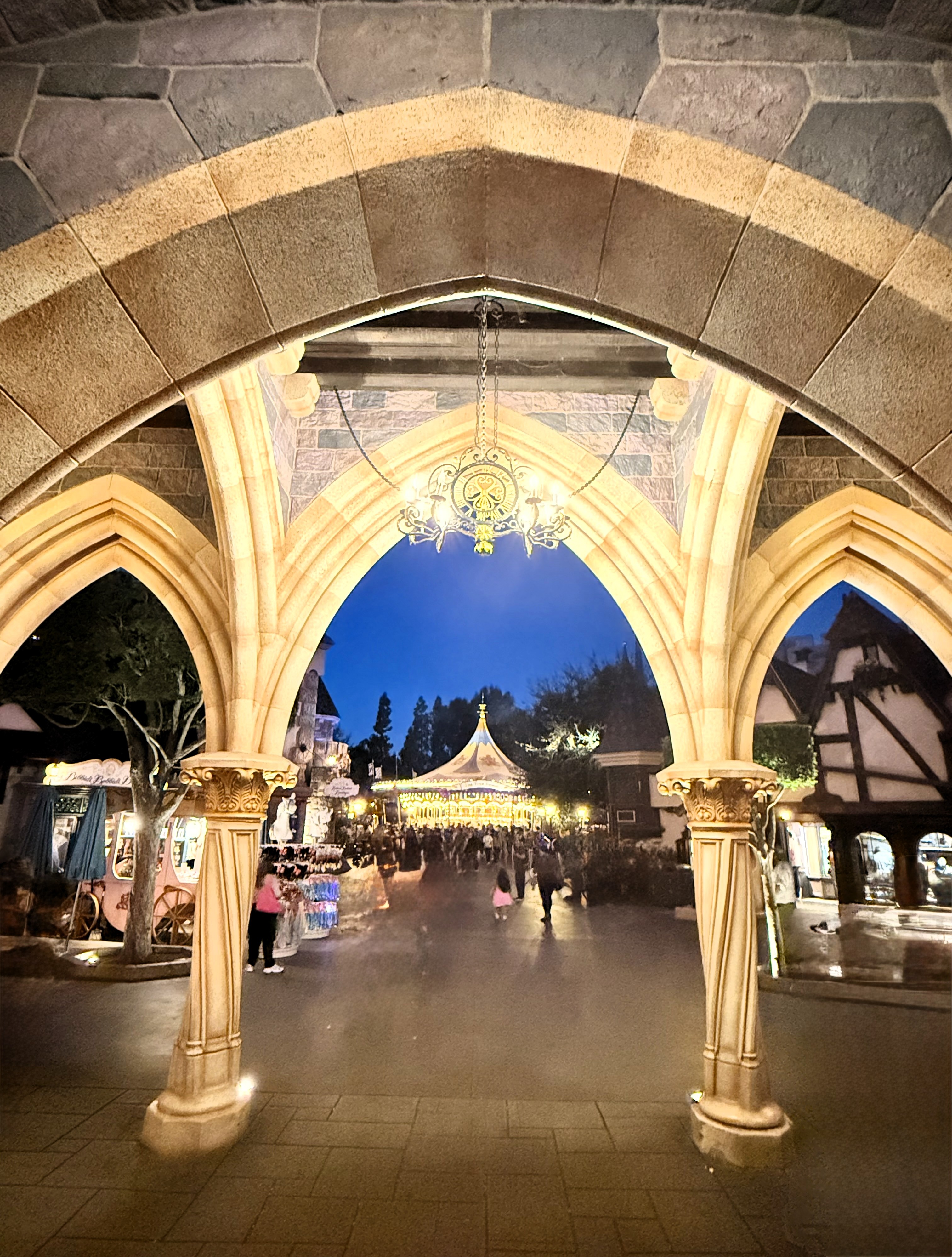 Stone archways of Sleeping Beauty Castle opening onto Fantasyland